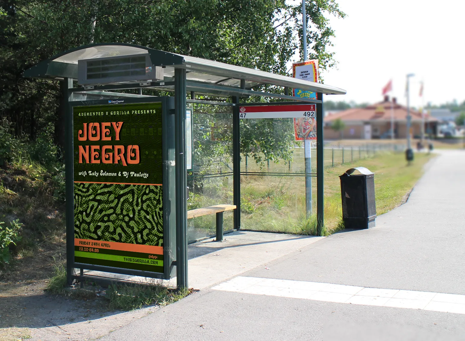 The poster in a bus shelter, photographed on a suburban road.