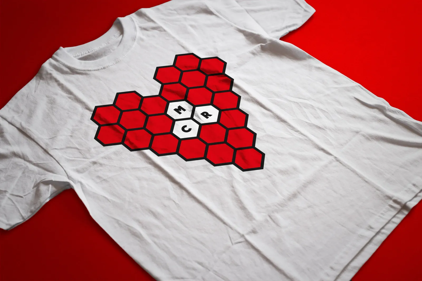 The bee heart printed on a white t-shirt, photographed on a red ground.